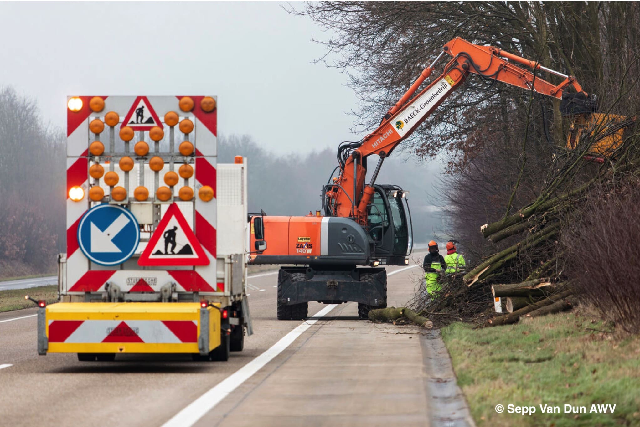 Hakhoutwerken langs een Vlaamse weg met kort gesnoeide bomen en struiken